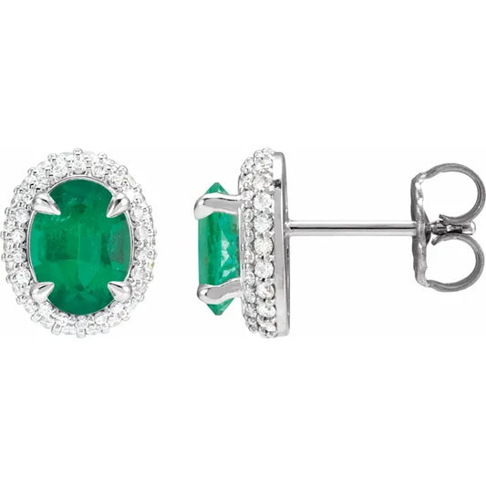 A pair of diamond-crowned emerald stud earrings with a double halo design, set in 14K white gold.