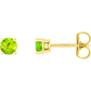 14K yellow gold stud earrings featuring vibrant round-cut peridot gemstones in a four-prong setting, shown from both front and side angles on a white background.