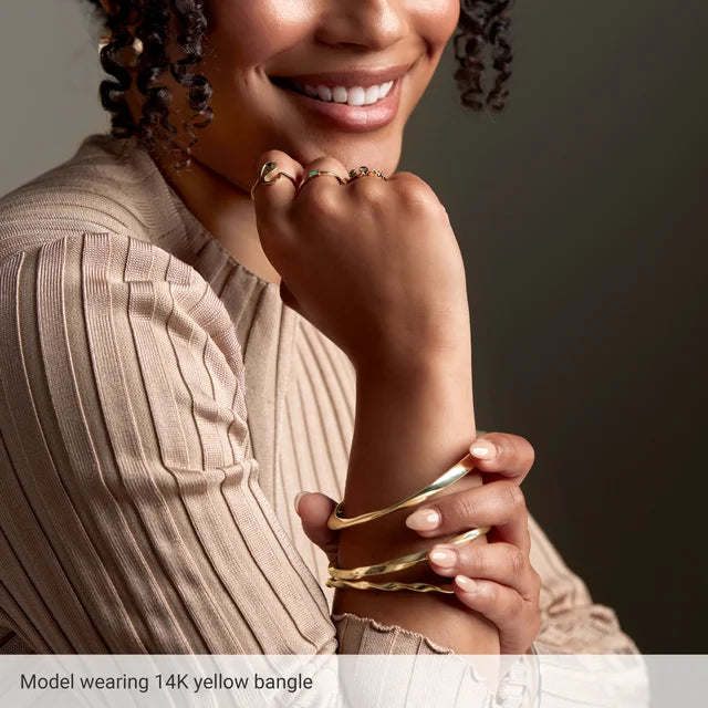 picture of a model wearing gold Wavy Bangle Bracelets