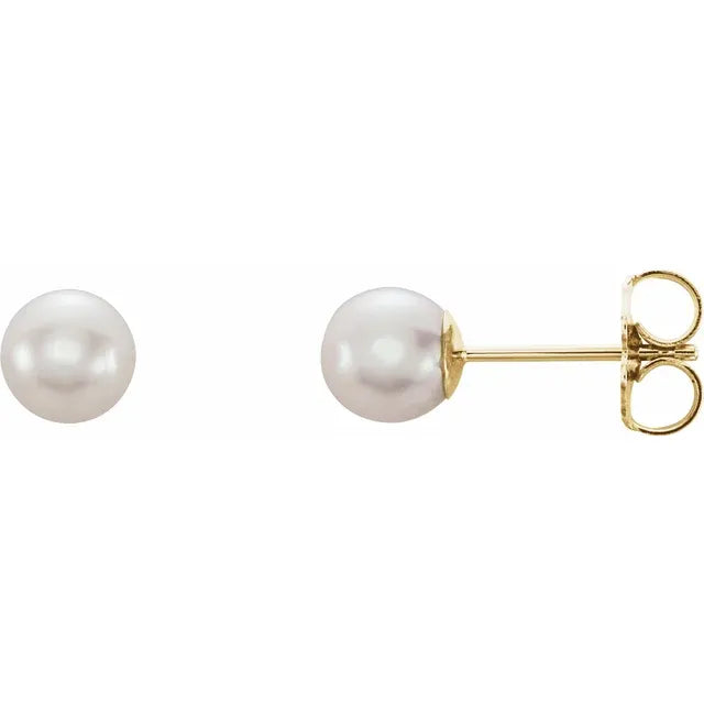pair of white cultured freshwater pearl stud earrings near round shape with soft luster in yellow gold